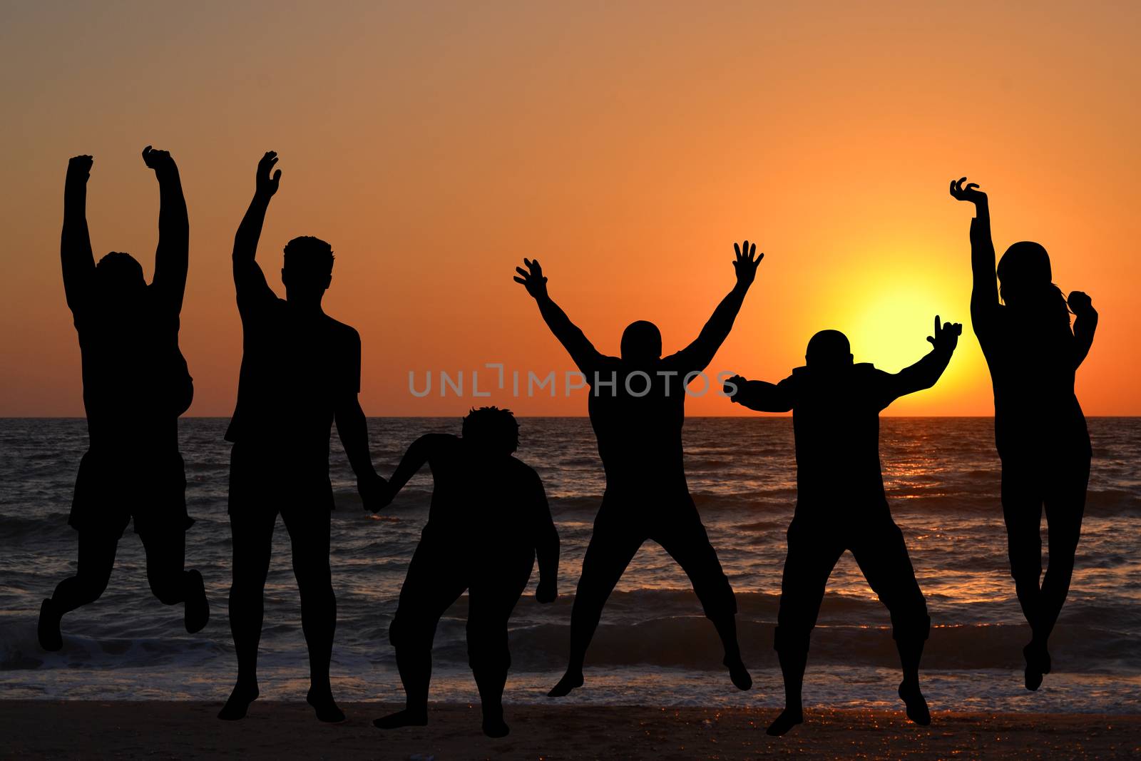 Silhouettes of people jumping on beach