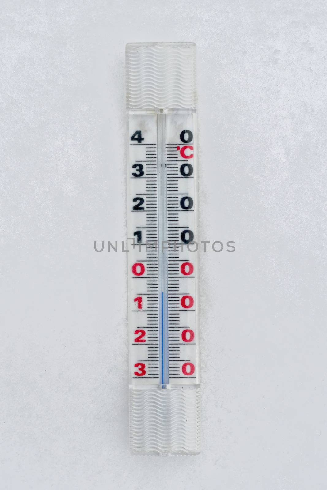 A thermometer placed on the snow with minus temperature