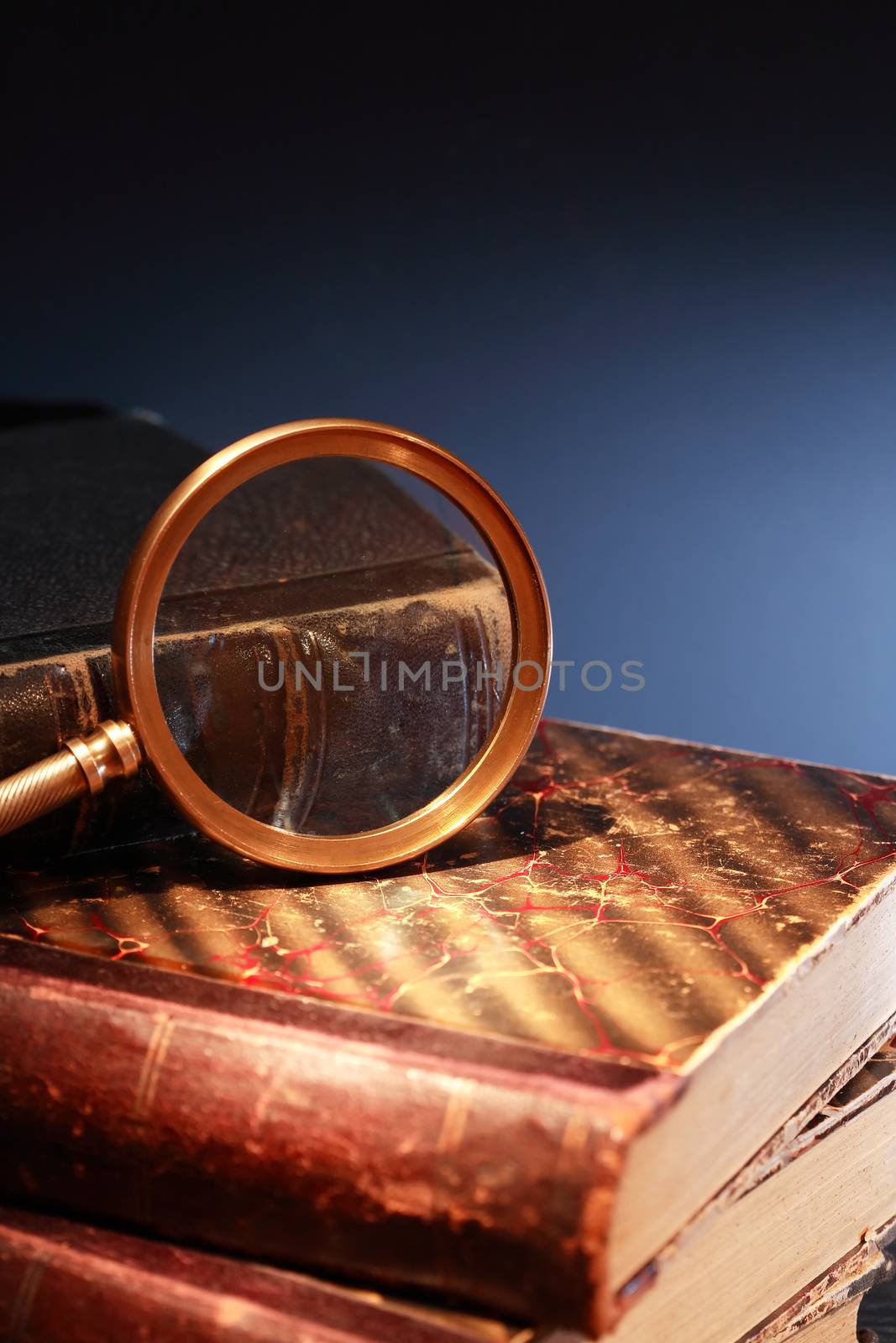 Vintage library. Closeup of magnifying glass on old book