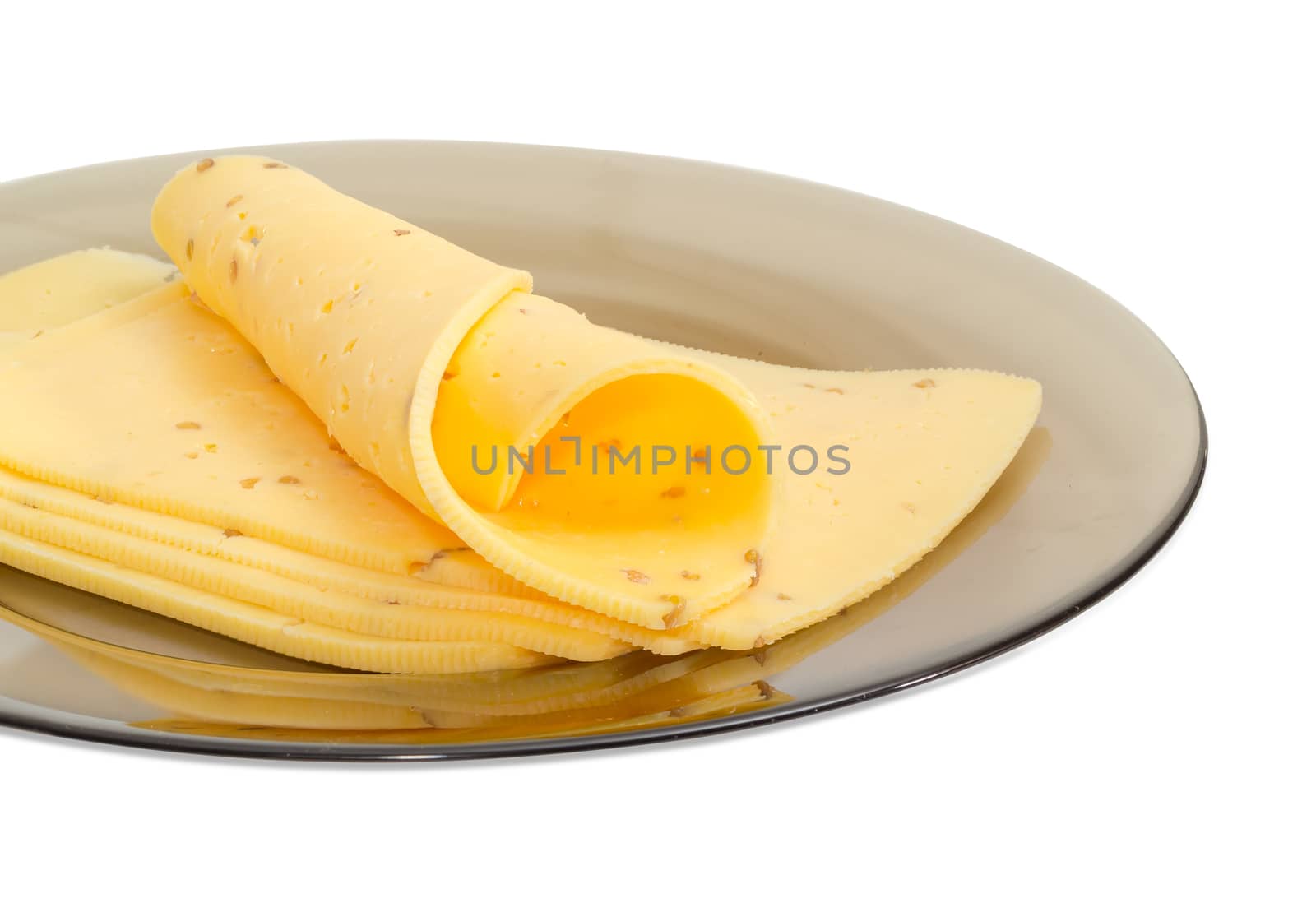 Fragment of glass dish with several slices of a semi-hard cheese made with pounded walnuts closeup on a light background
