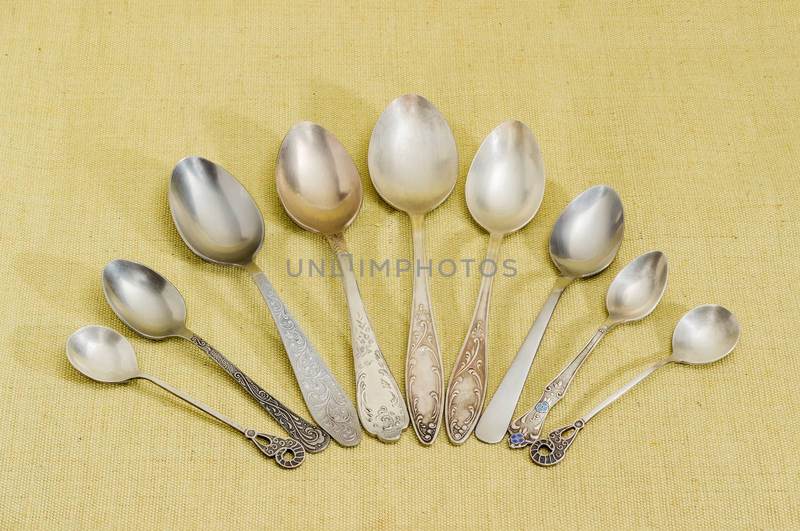 Several different old spoons on cloth by anmbph