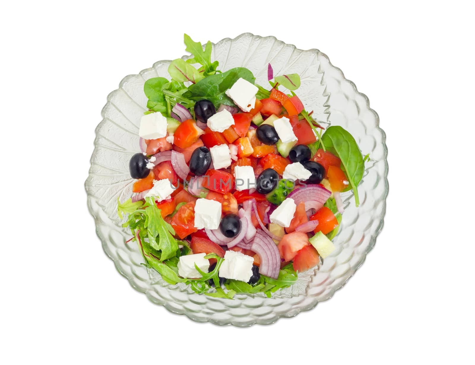 Top view of greek salad in a glass salad bowl on a white background
