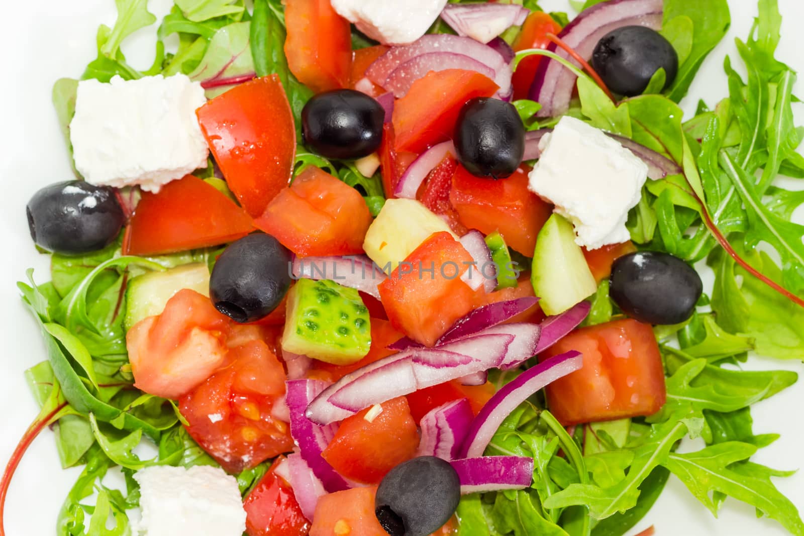 Top view of a Greek salad in a white dish closeup
