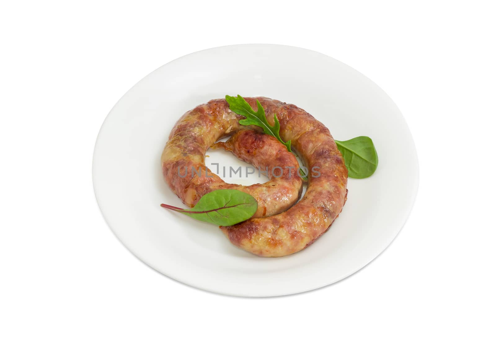 Freshly roasted pork sausage in natural casing with few leaves of different greens on a white dish on a light background
