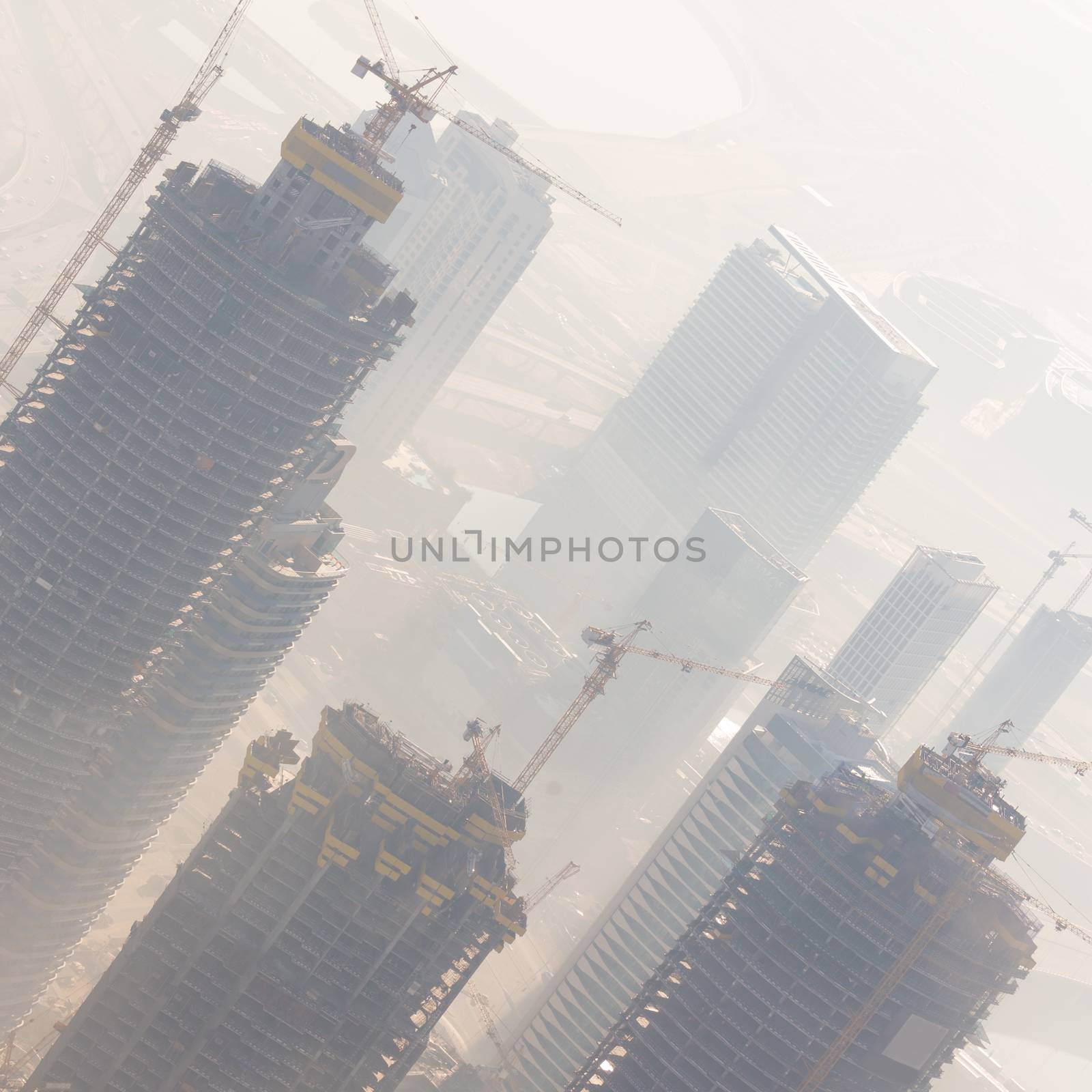 Huge skyscrappers construction site with cranes on top of buildings. Rapid urban and construction sector development or inflation of real estate bubble.