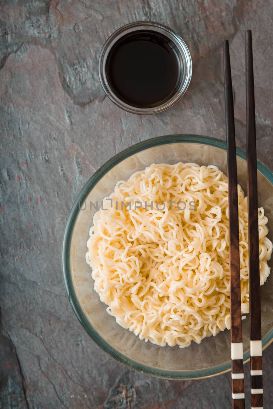 Soup Ramen noodles in glass bowl and sause on tte gray table by Deniskarpenkov