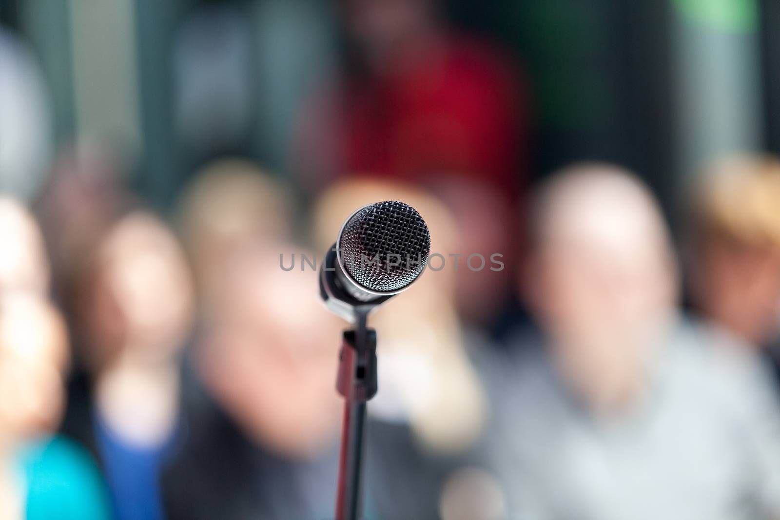 Microphone in focus against blurred group of people