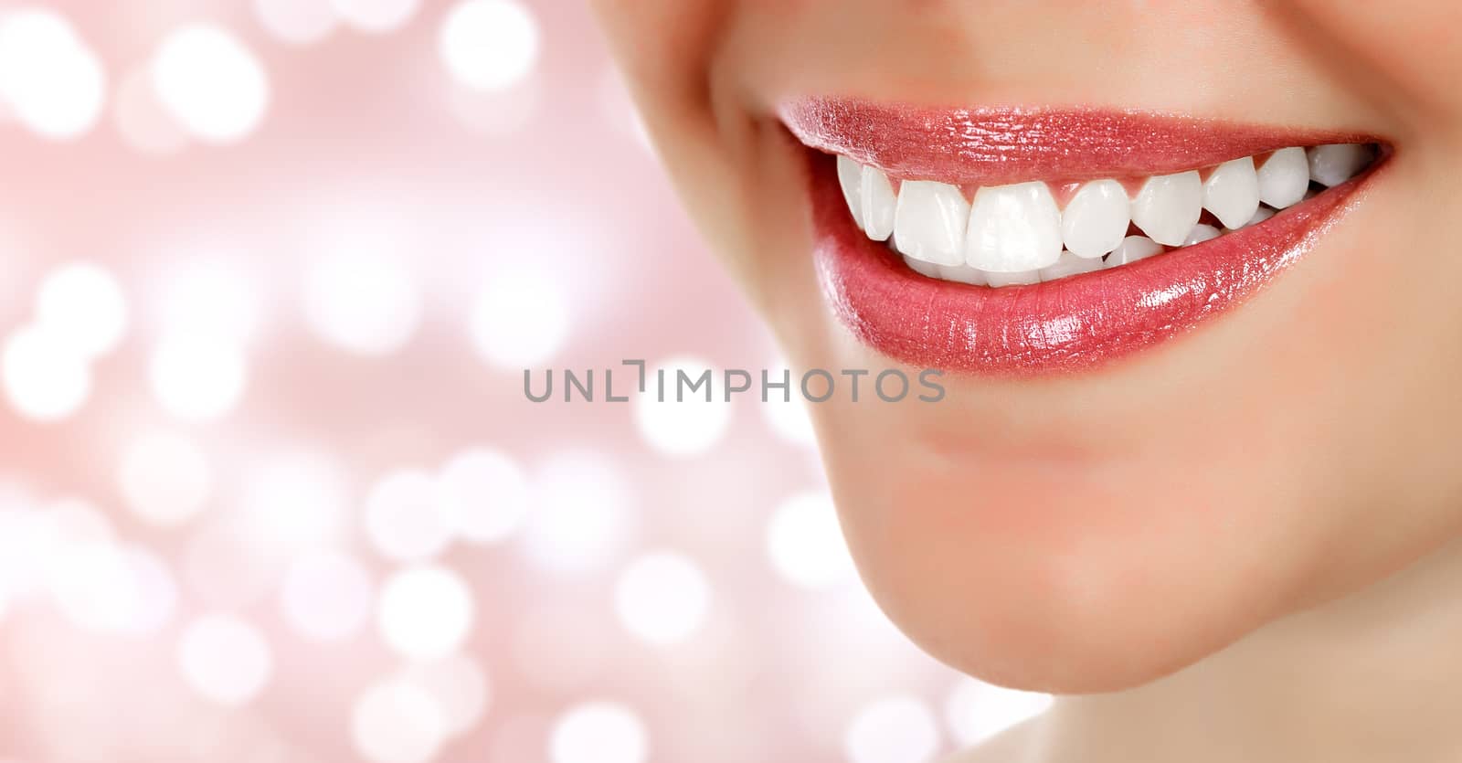 Woman smile closeup against an abstract background with blurred lights