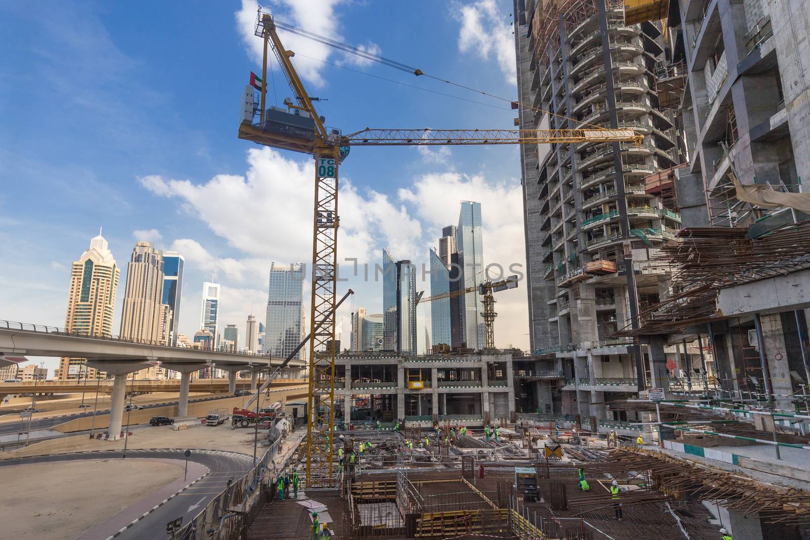 Laborers working on modern constraction site works in Dubai. Fast urban development consept.