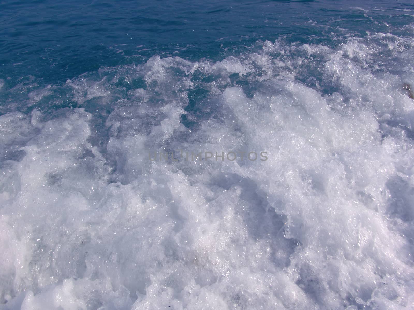 Foam in seawater. Deep blue sea water with foam