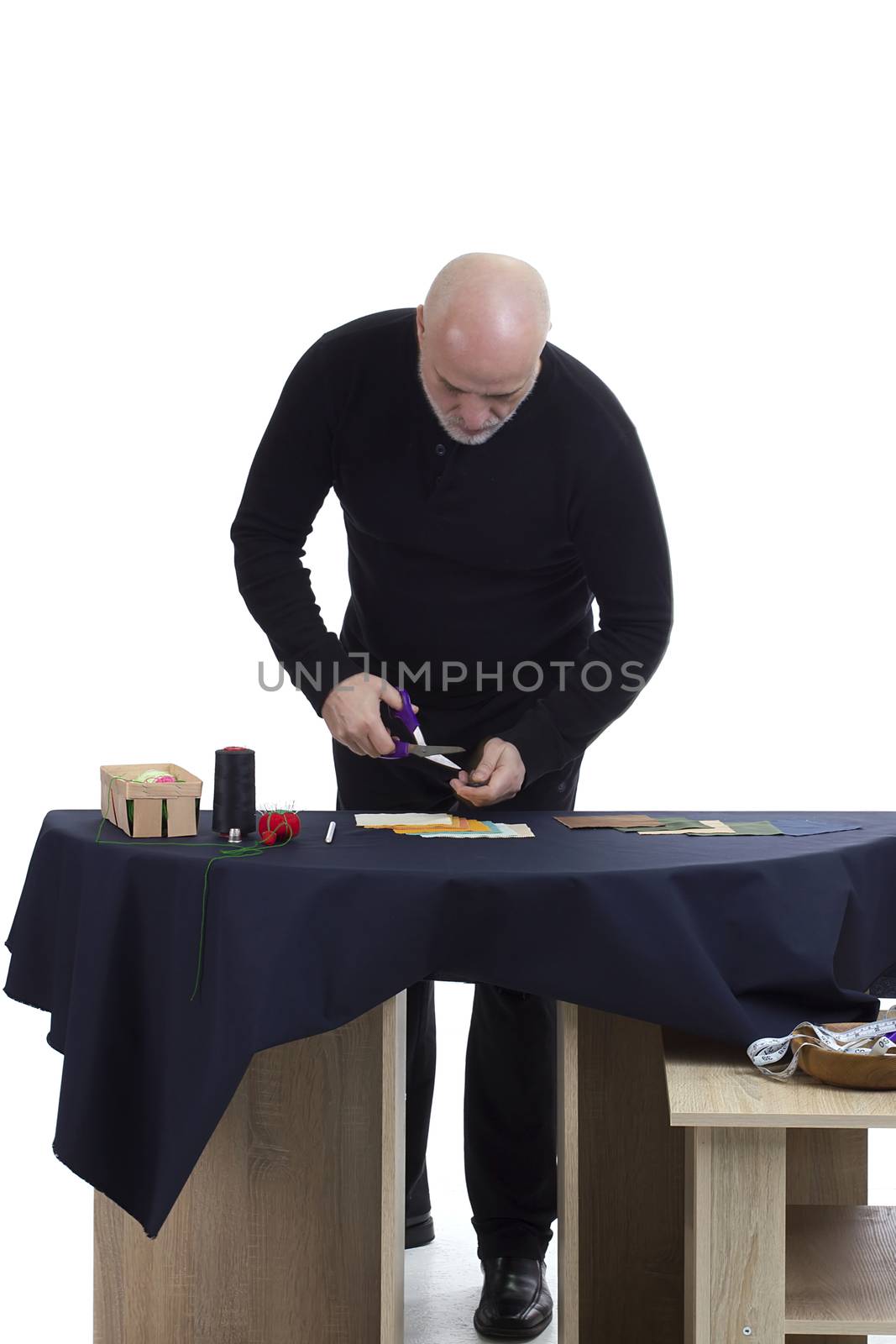 Mature tailor at work on a white background
