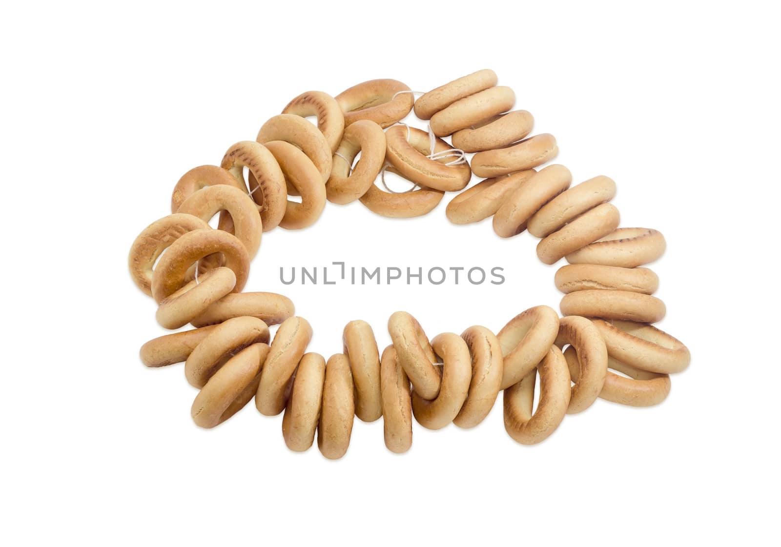 Bunch of small round bagels tied by cord on a light background 
