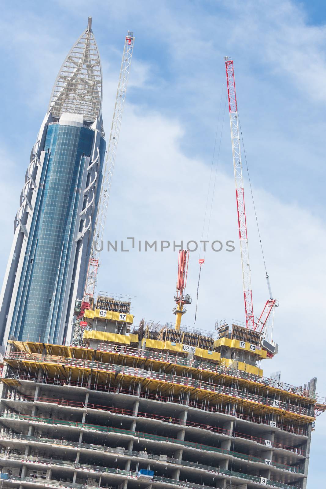 Skyscrappers construction site with cranes on top of buildings. by kasto