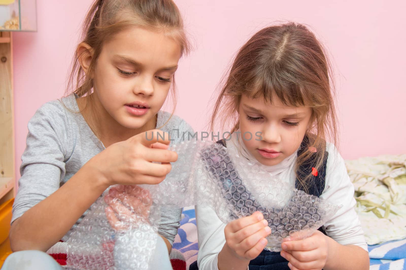 Two girls captivated bubbles burst inflatable packaging package