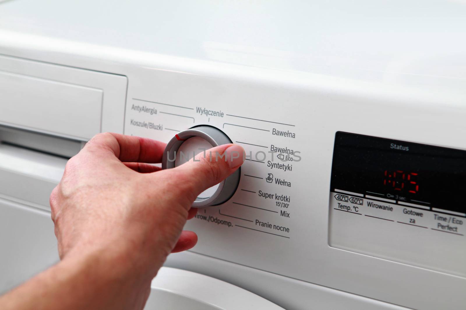 Close up of man hand adjusting washing machine
