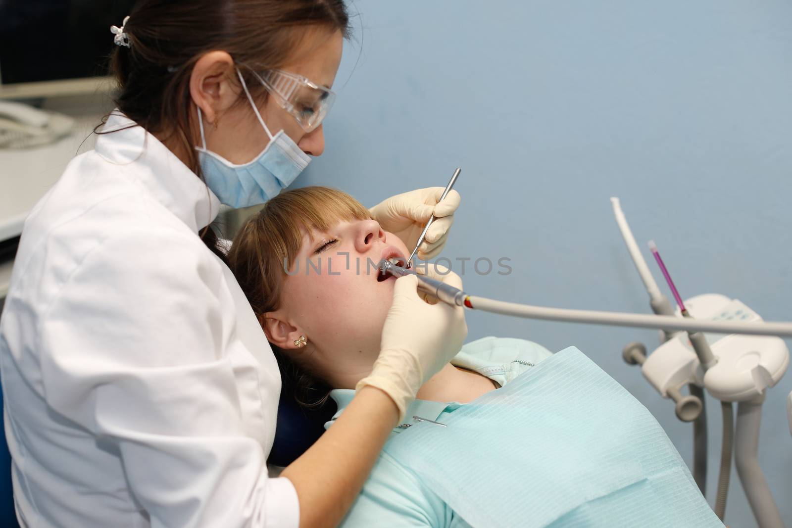 Dentist in a private office holds reception of the patient with pain. The Dentist Selects The Tool And Starts Examination Of The Teeth.