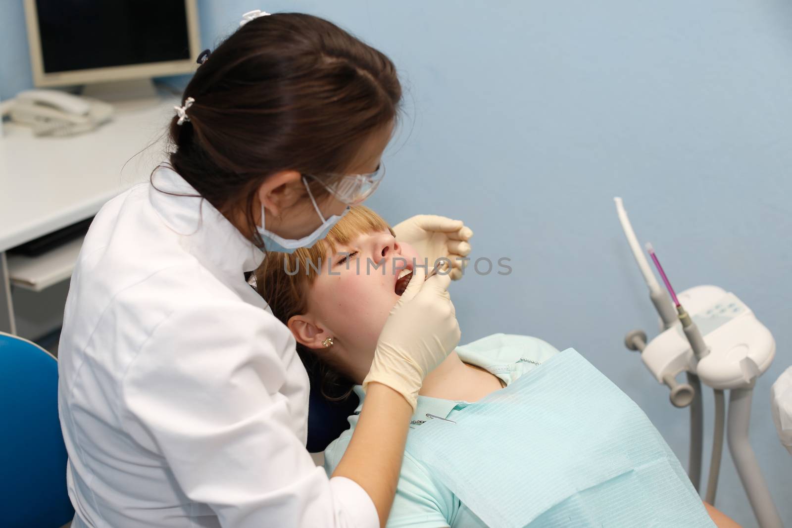 Dentist in a private office holds reception of the patient with pain. The Dentist Selects The Tool And Starts Examination Of The Teeth.