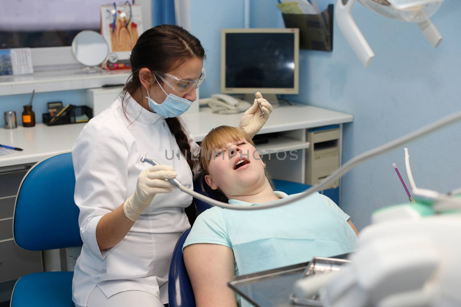 Dentist in a private office holds reception of the patient with pain. The Dentist Selects The Tool And Starts Examination Of The Teeth.