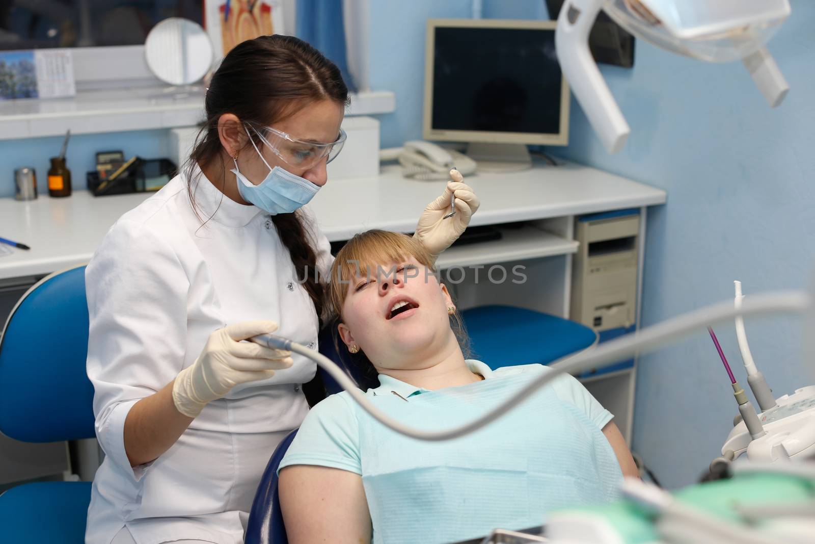 Dentist in a private office holds reception of the patient with pain. The Dentist Selects The Tool And Starts Examination Of The Teeth.