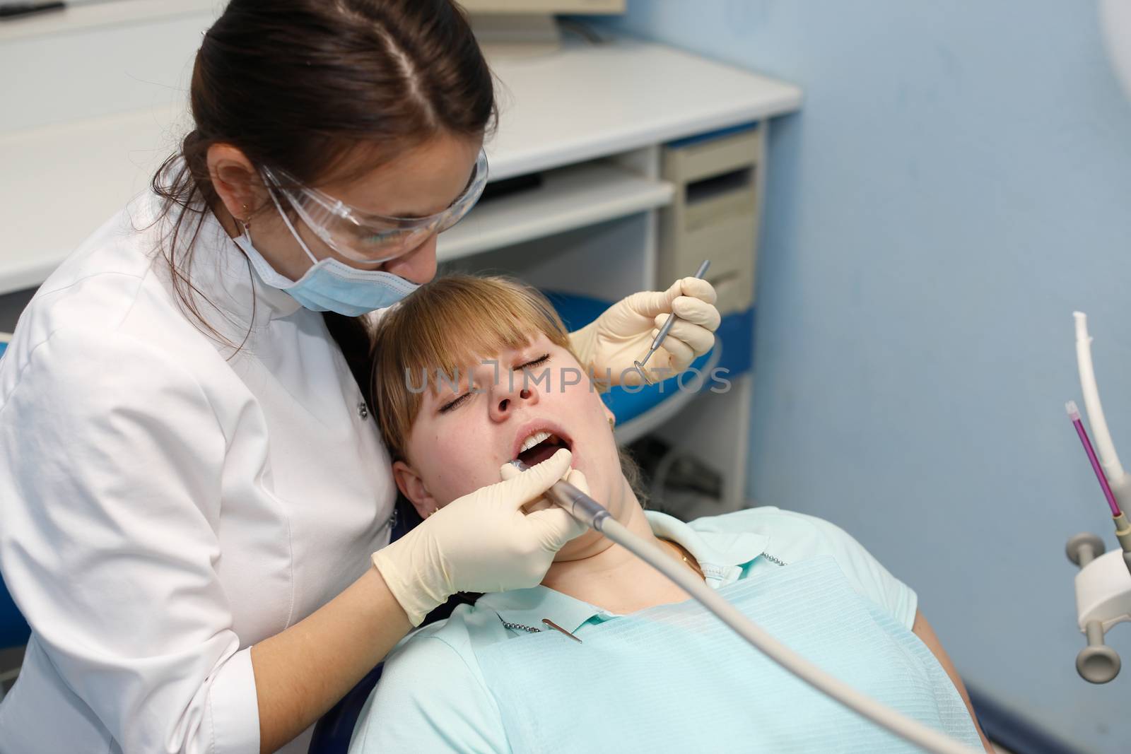 Dentist in a private office holds reception of the patient with pain. The Dentist Selects The Tool And Starts Examination Of The Teeth.