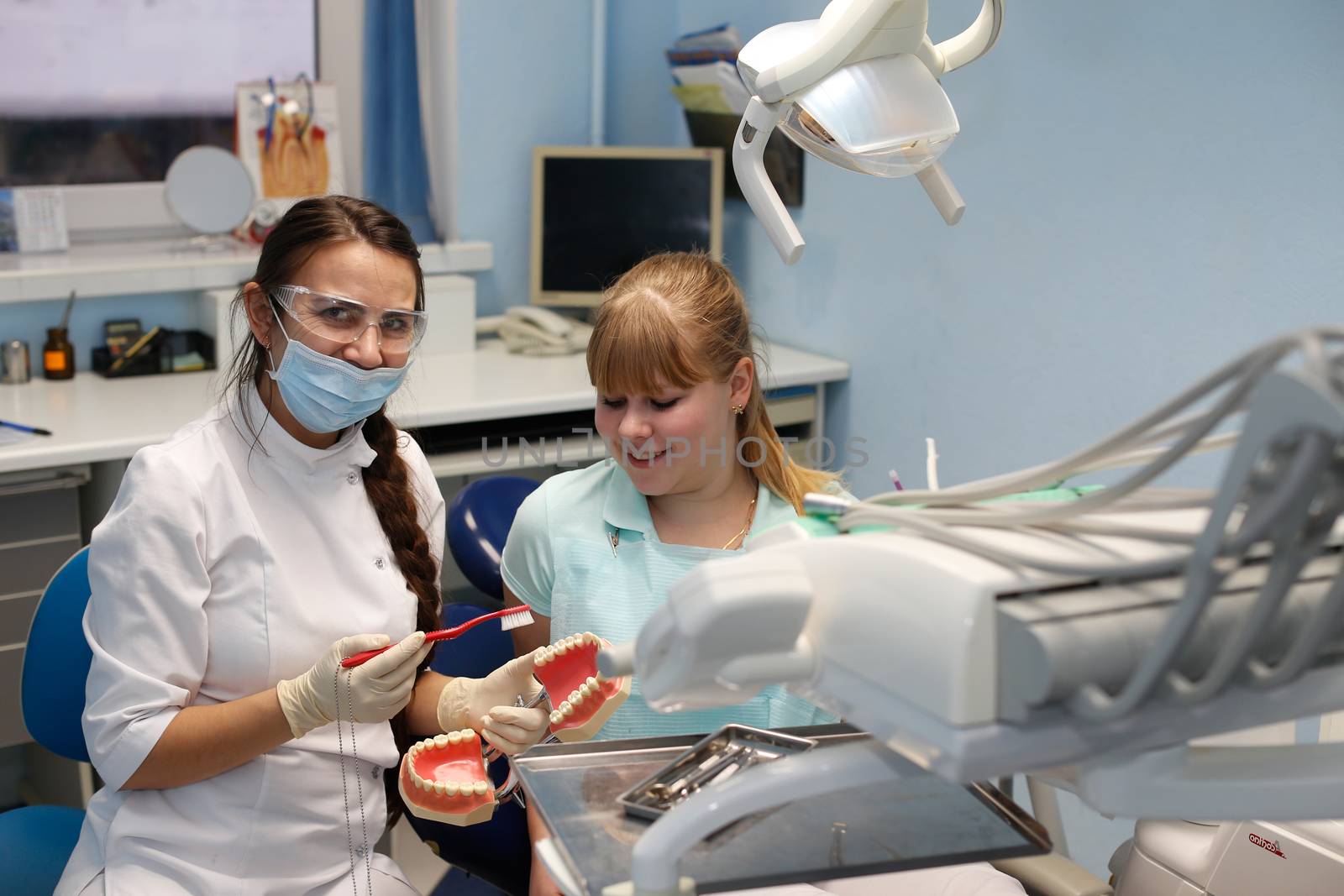 Dentist in a private office holds reception of the patient with pain. The Dentist Selects The Tool And Starts Examination Of The Teeth.