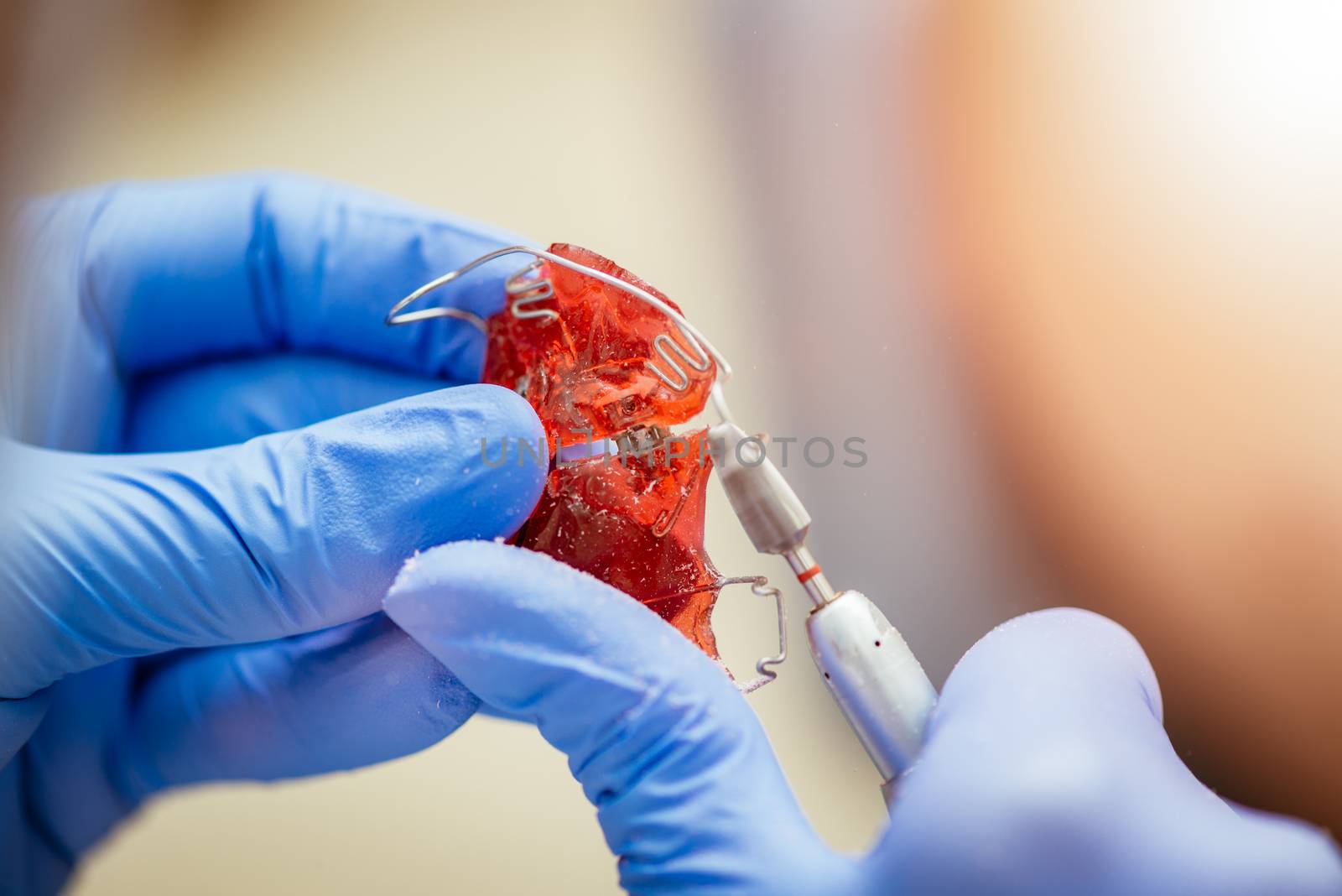 Close-up of a hands of a dentist doing correction on mobile denture.