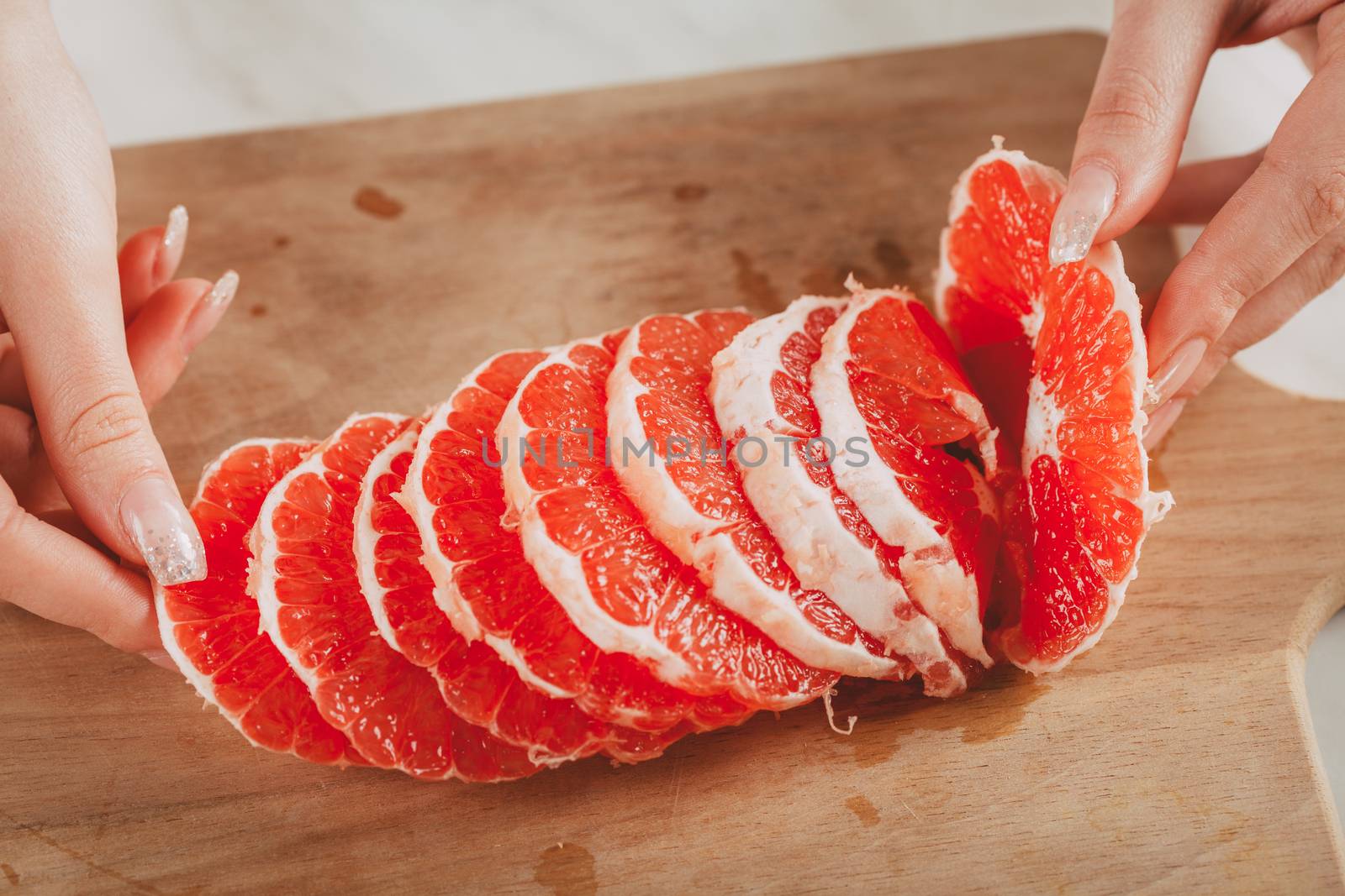 Close-up of a sliced red grapefruit on the kitchen board.