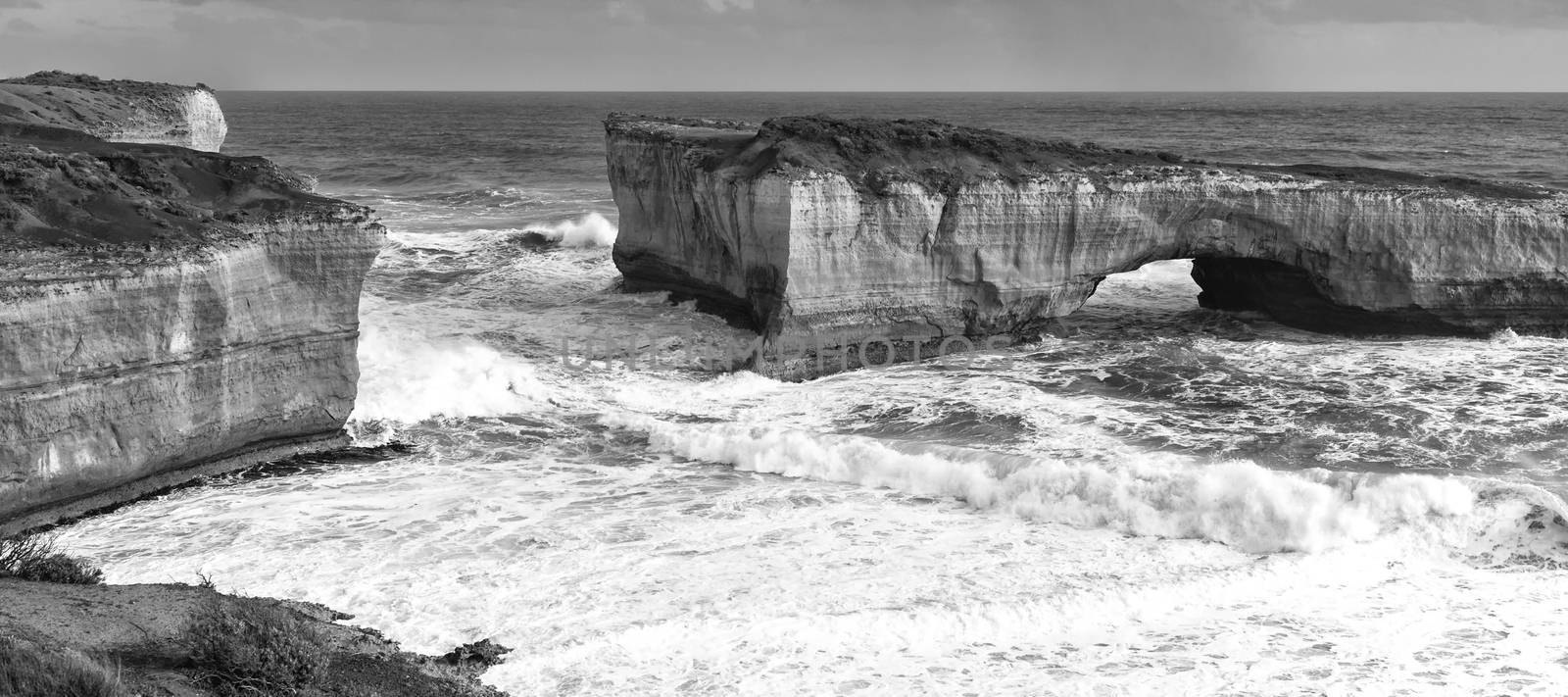 View of the London Bridge on Great Ocean Road during the day. Black and White.