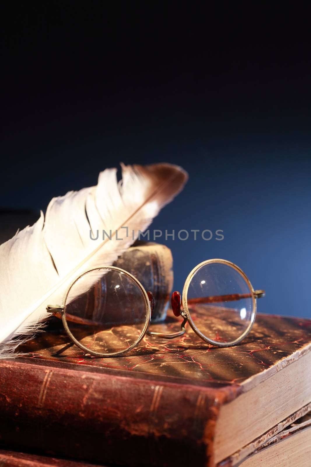 Vintage still life. Quill pen and spectacles on old books