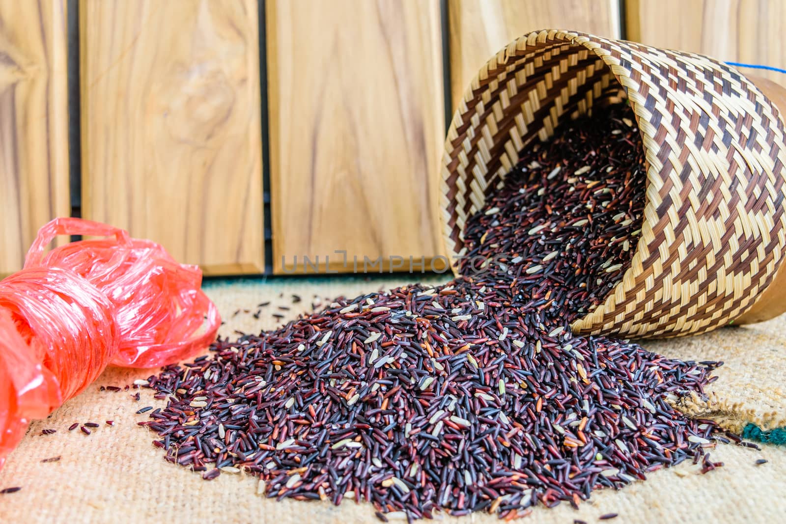 Hom Nil (black jasmine rice) in kratip on sack wooden background