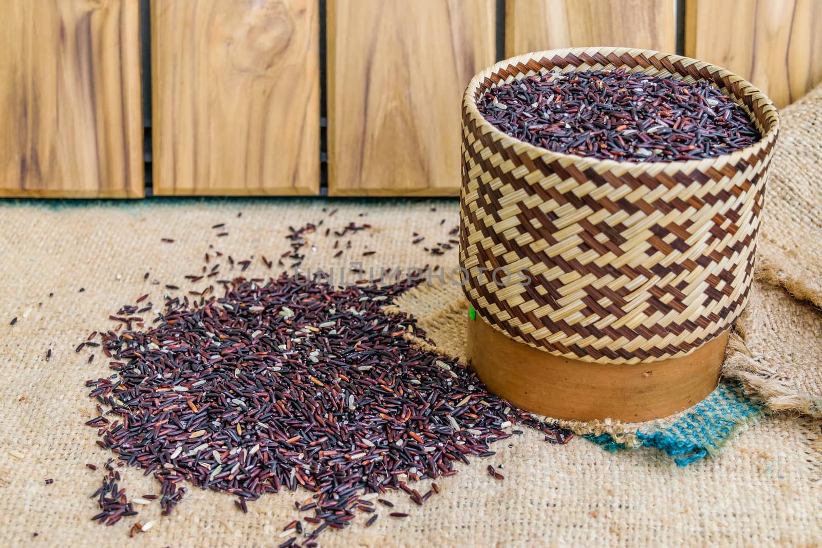 Hom Nil (black jasmine rice) in kratip on wood background