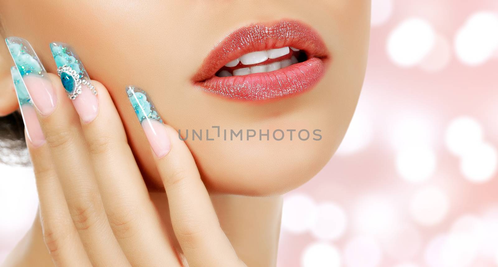 Part of female face and manicured fingers on an abstract background with blurred lights