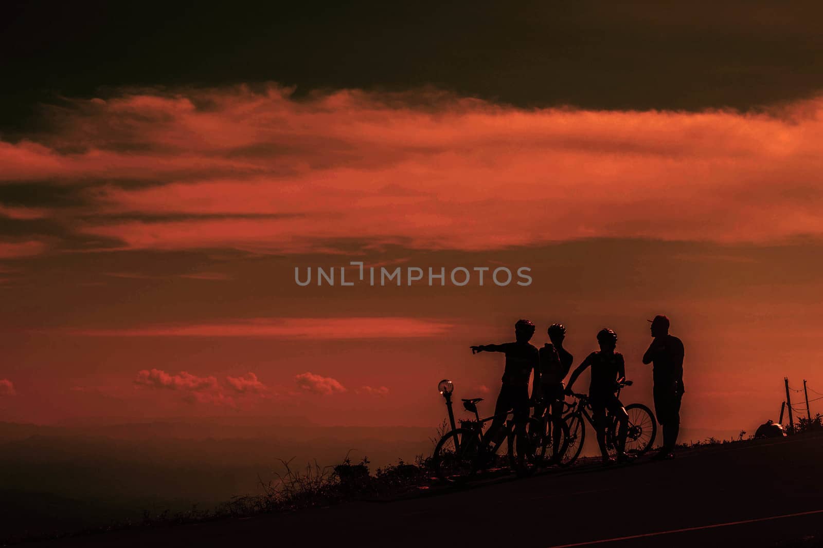Cyclists group to view the sky at sunset.