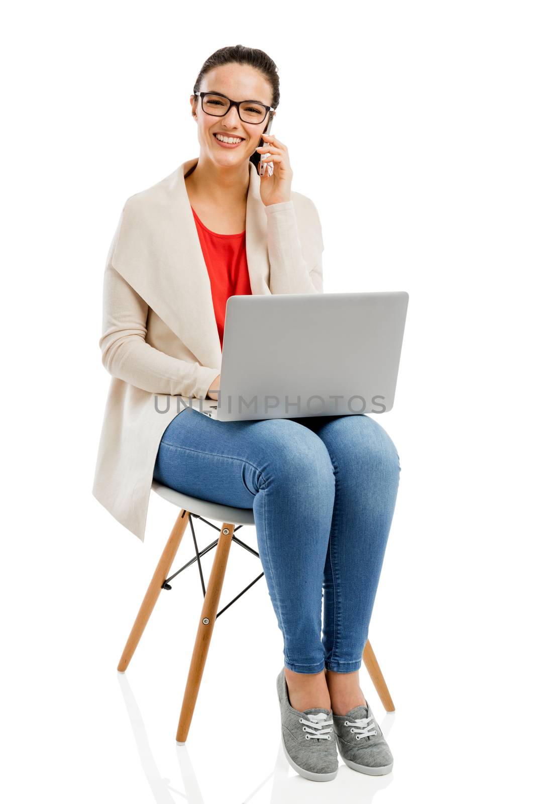 Beautiful and happy woman working with a laptop, isolated over white background 