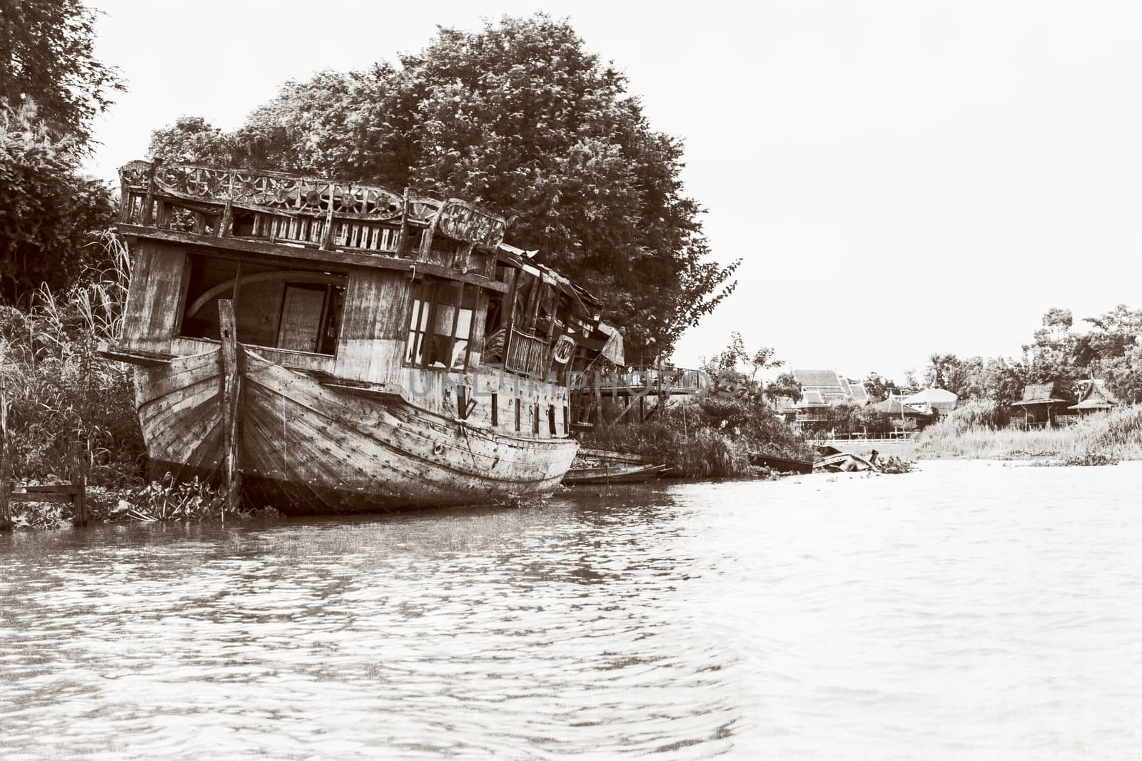 Black and white photo add texture vintage style of the old damaged wooden boat beached on the waterfront for background in Phra Nakhon Si Ayutthaya Province, Thailand