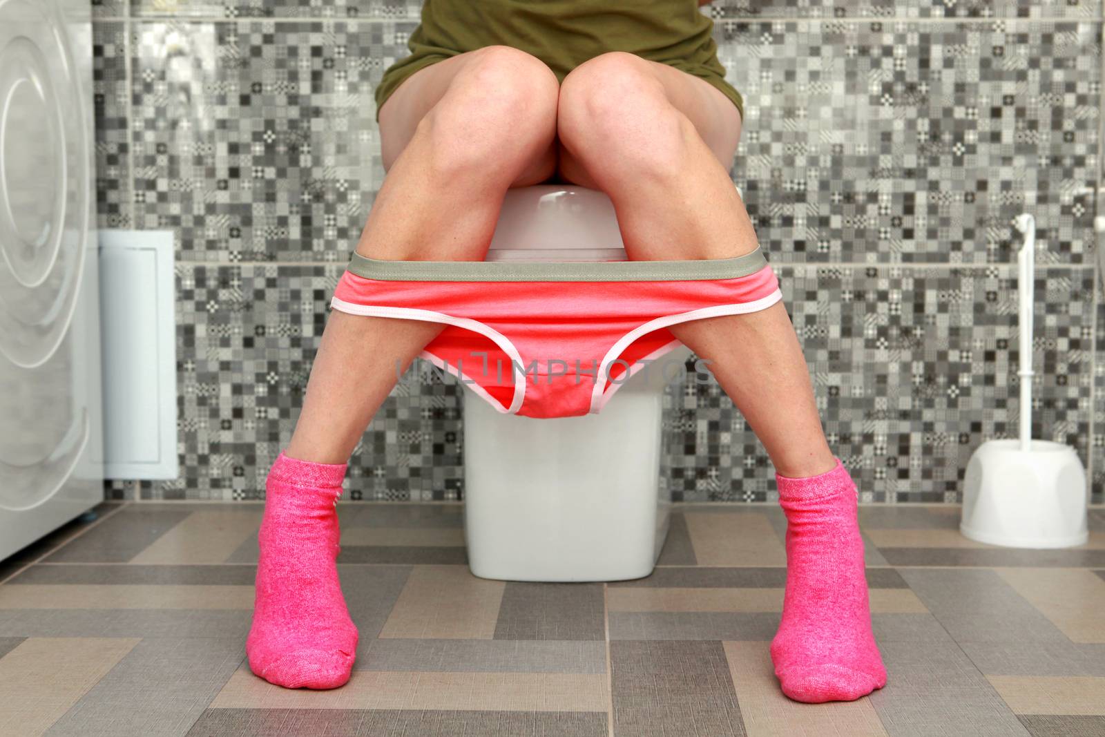 woman sits on toilet bowl by ssuaphoto