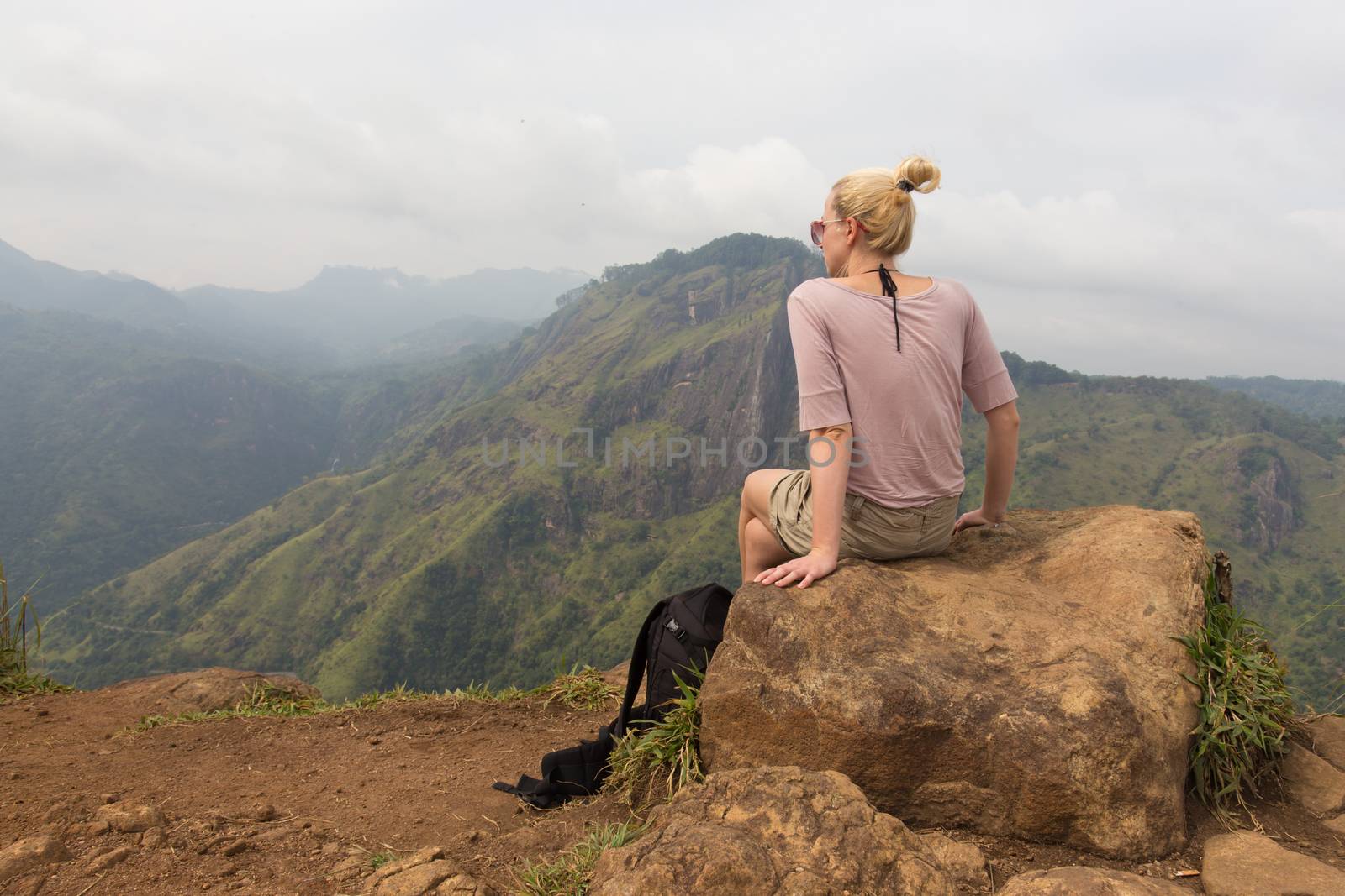 Woman enjoying pristine nature and beautiful view of tea plantations from the top of Small Adams peak near Ella, Sri Lanka. Tracking outdoors tourist adventure.