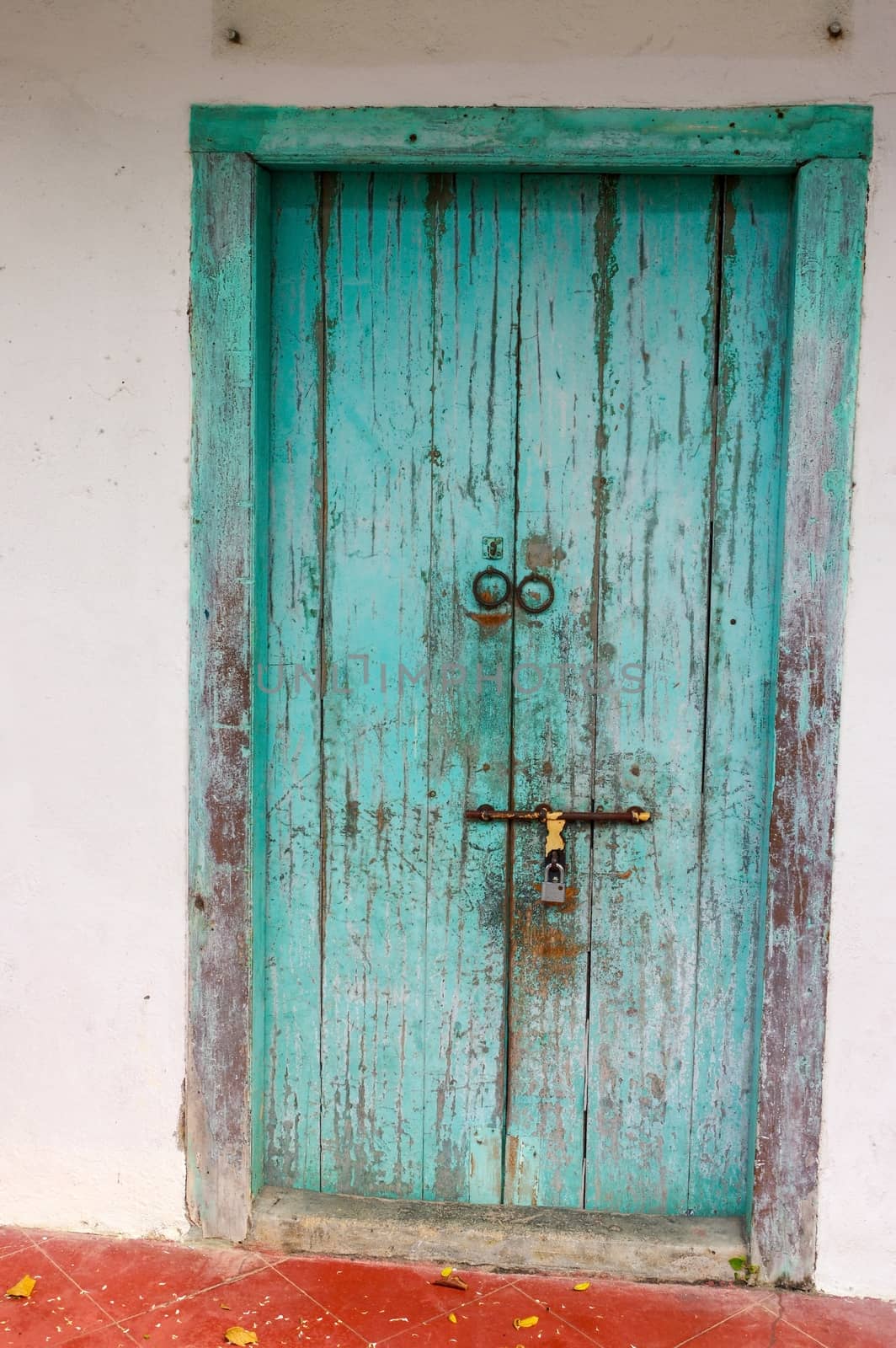 a closed old blue wooden door. Mediterranean style exterior.