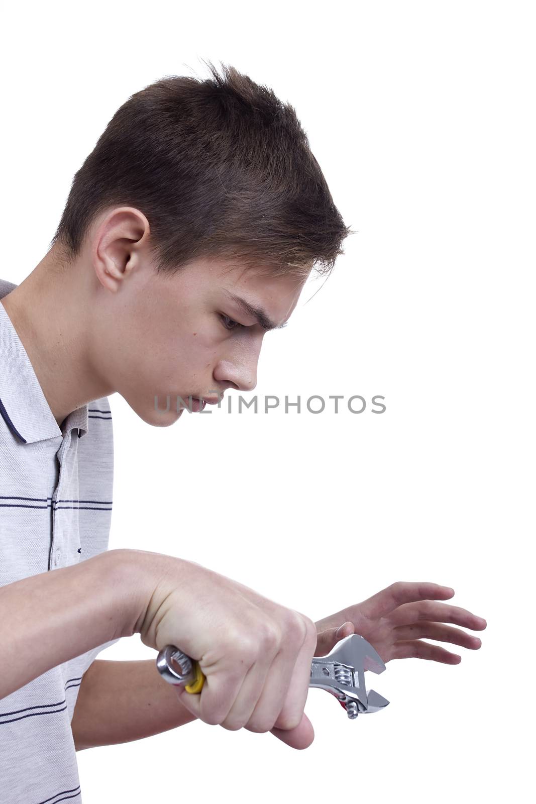 Young man holding metal wrench on a white background