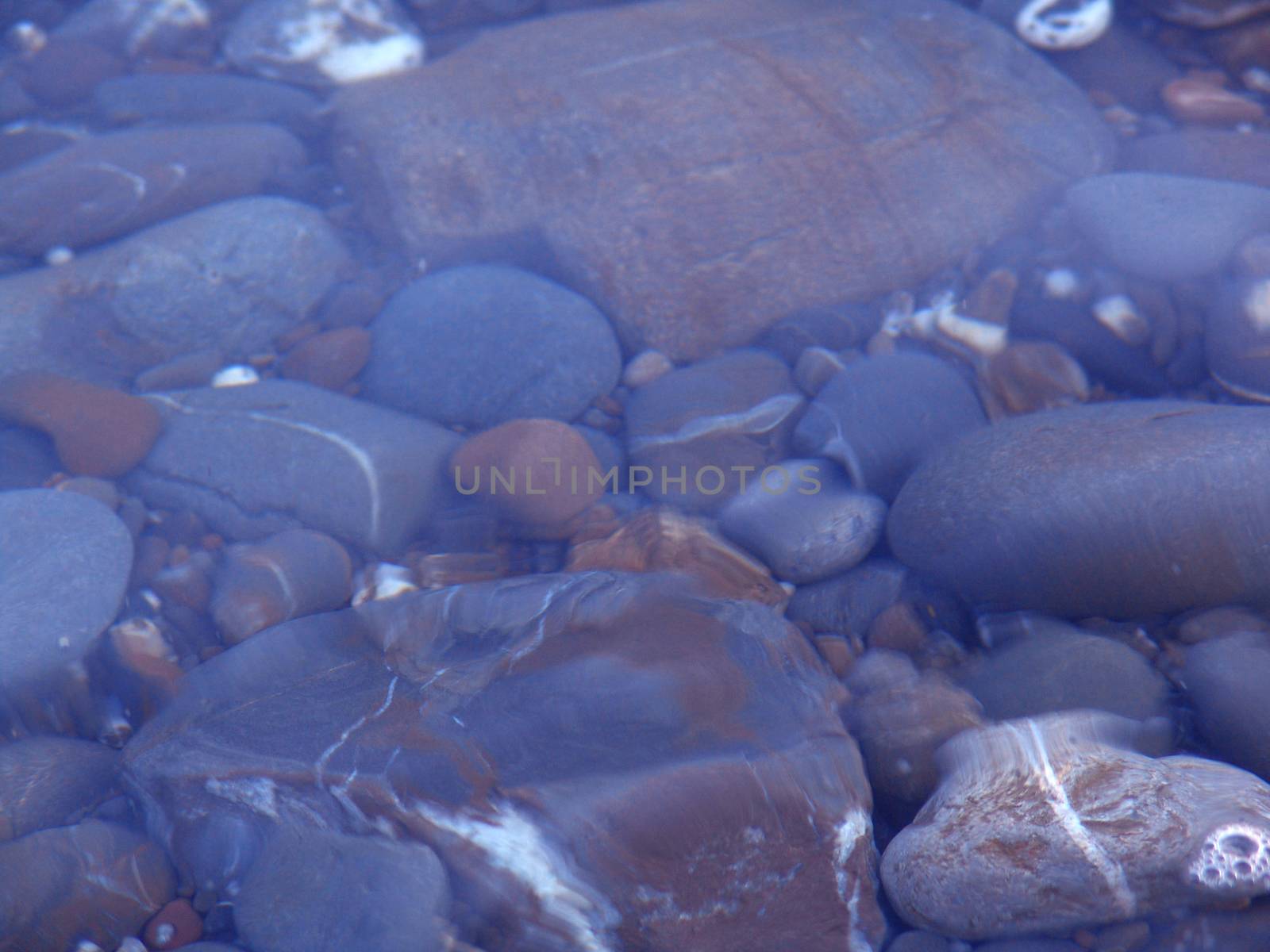 Pebbles seen through clear water. Usable as background