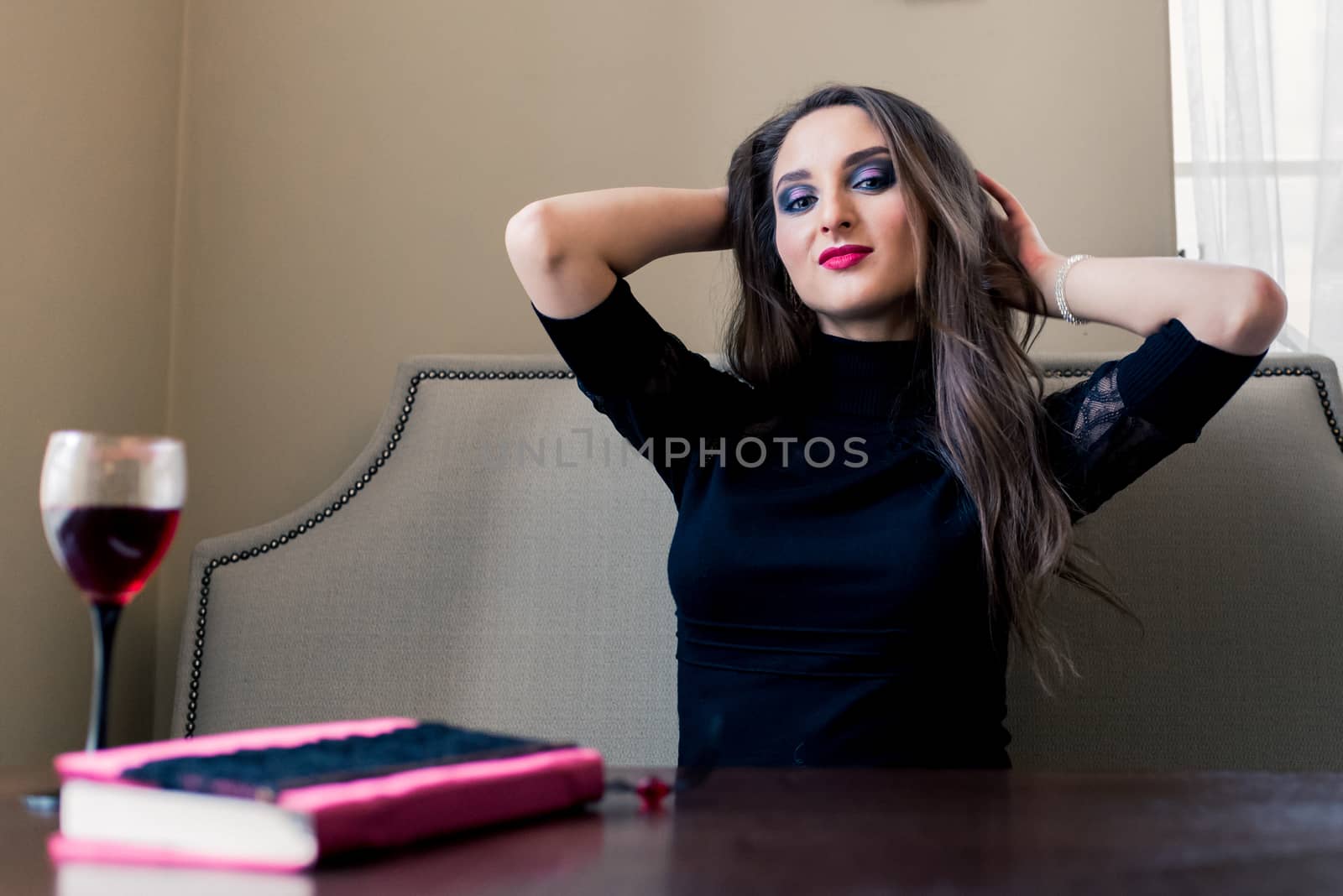 a beautiful girl sitting in the cafe with wine