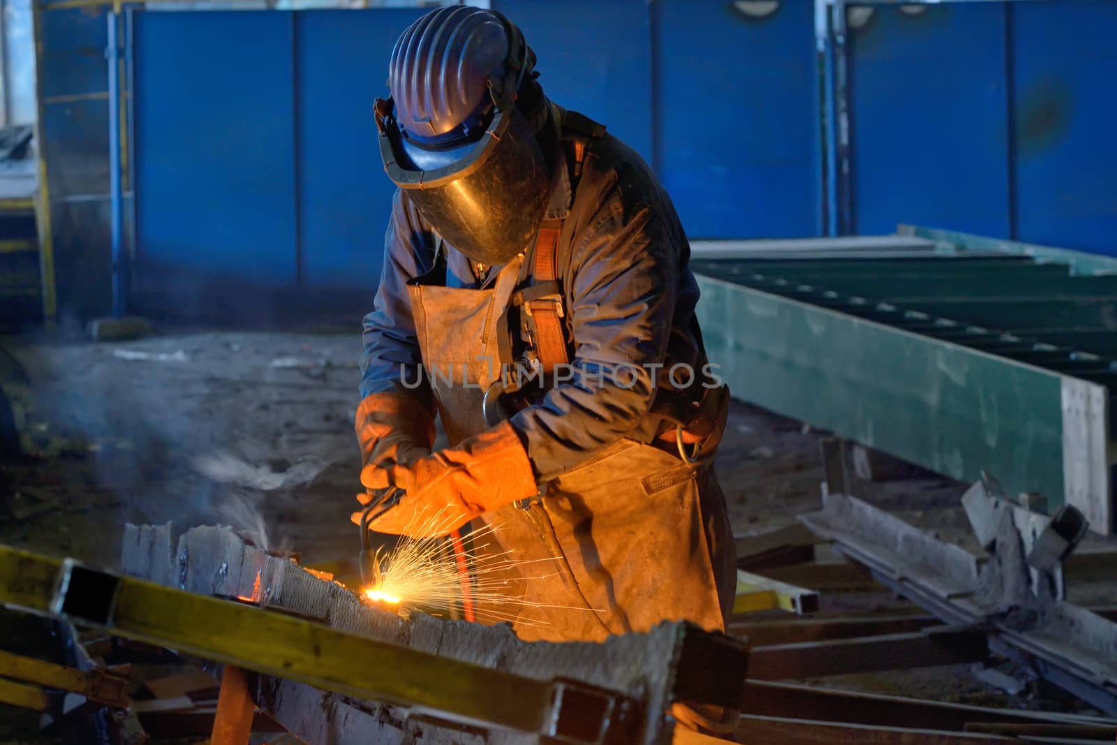 Welder welding metal in plant