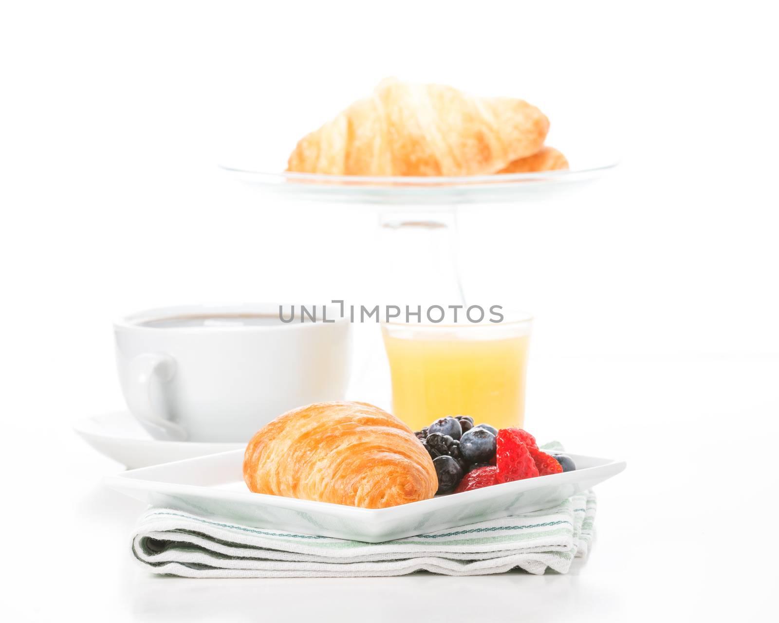 Fresh croissant and fruit served with coffee and orange juice.