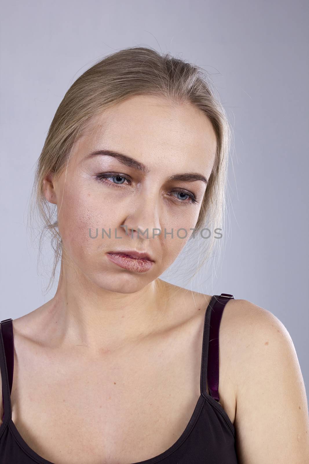 Portrait of a young woman in a gloom on the gray background. Seven Deadly Sins