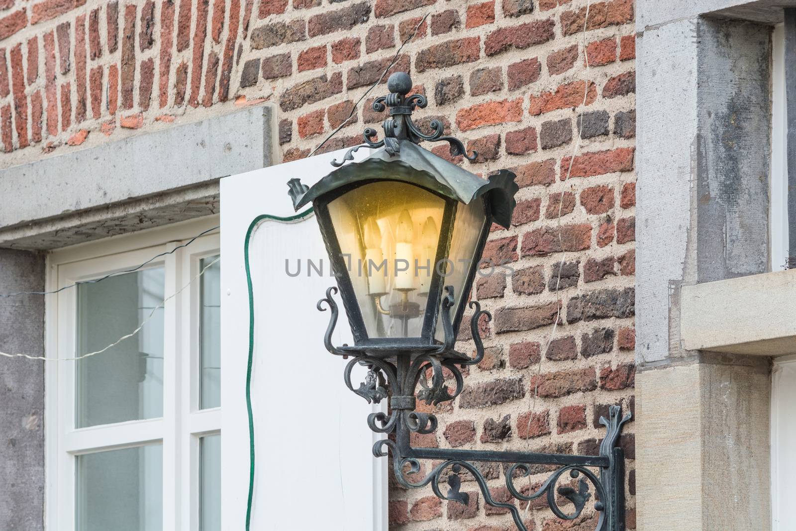Medieval illuminated street lantern made of wrought iron.