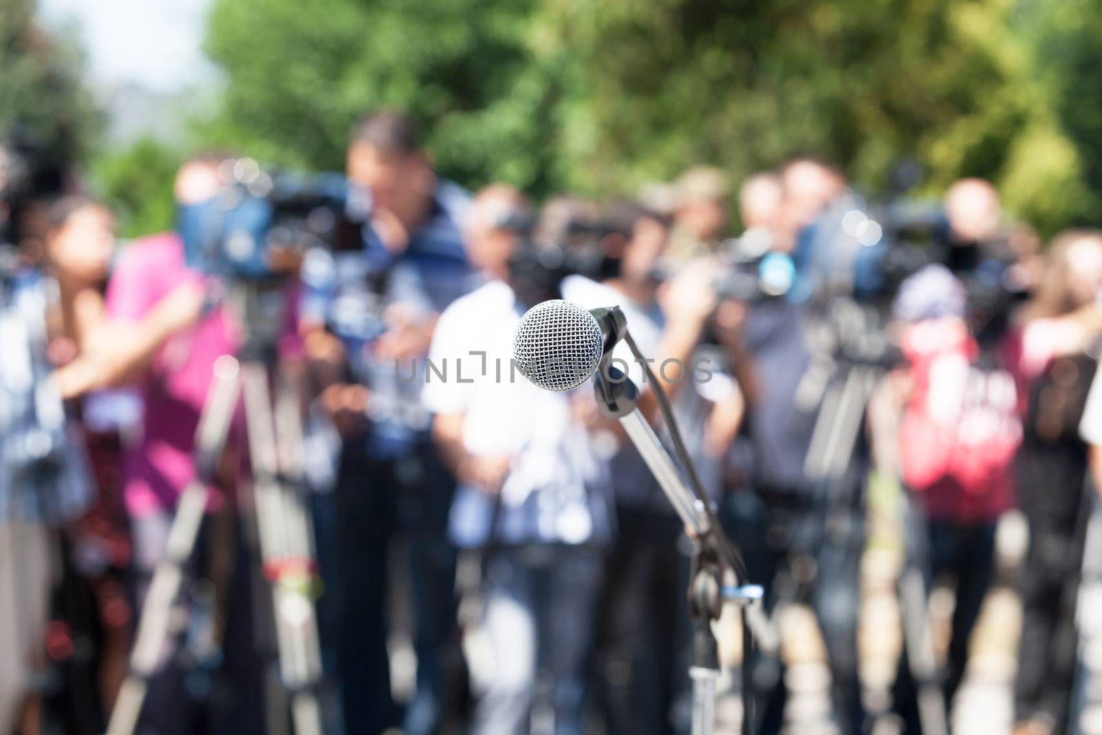 Press conference. Microphone in focus, blurred camera operators  by wellphoto