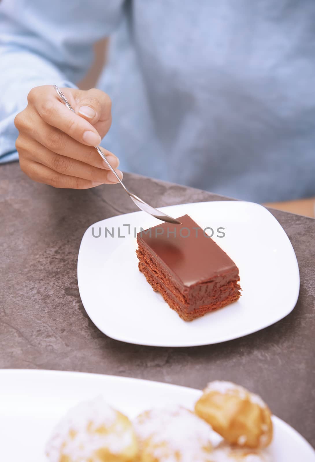 Hand of woman eating chocolate cake