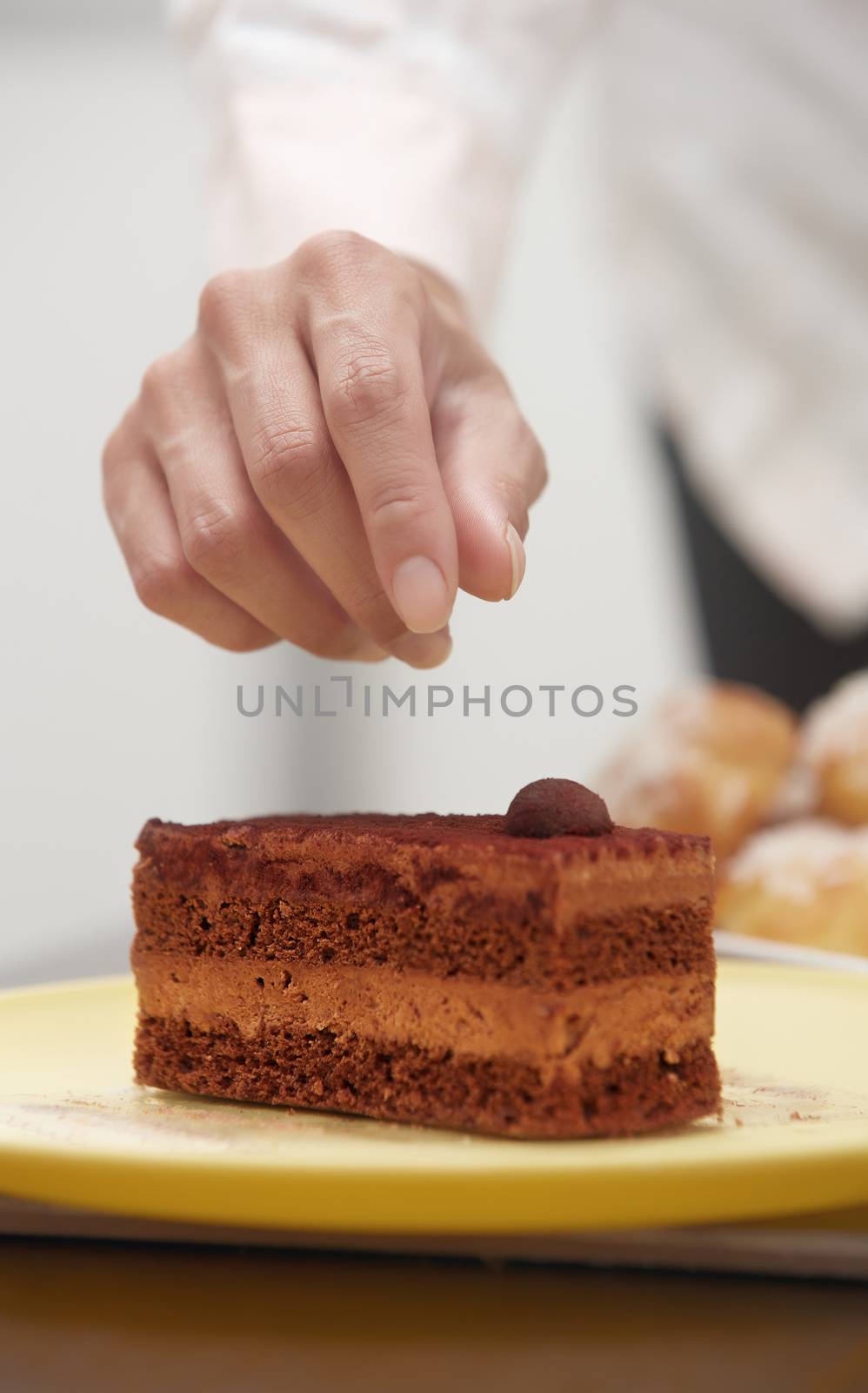 Woman confectioner preparing chocolate cake