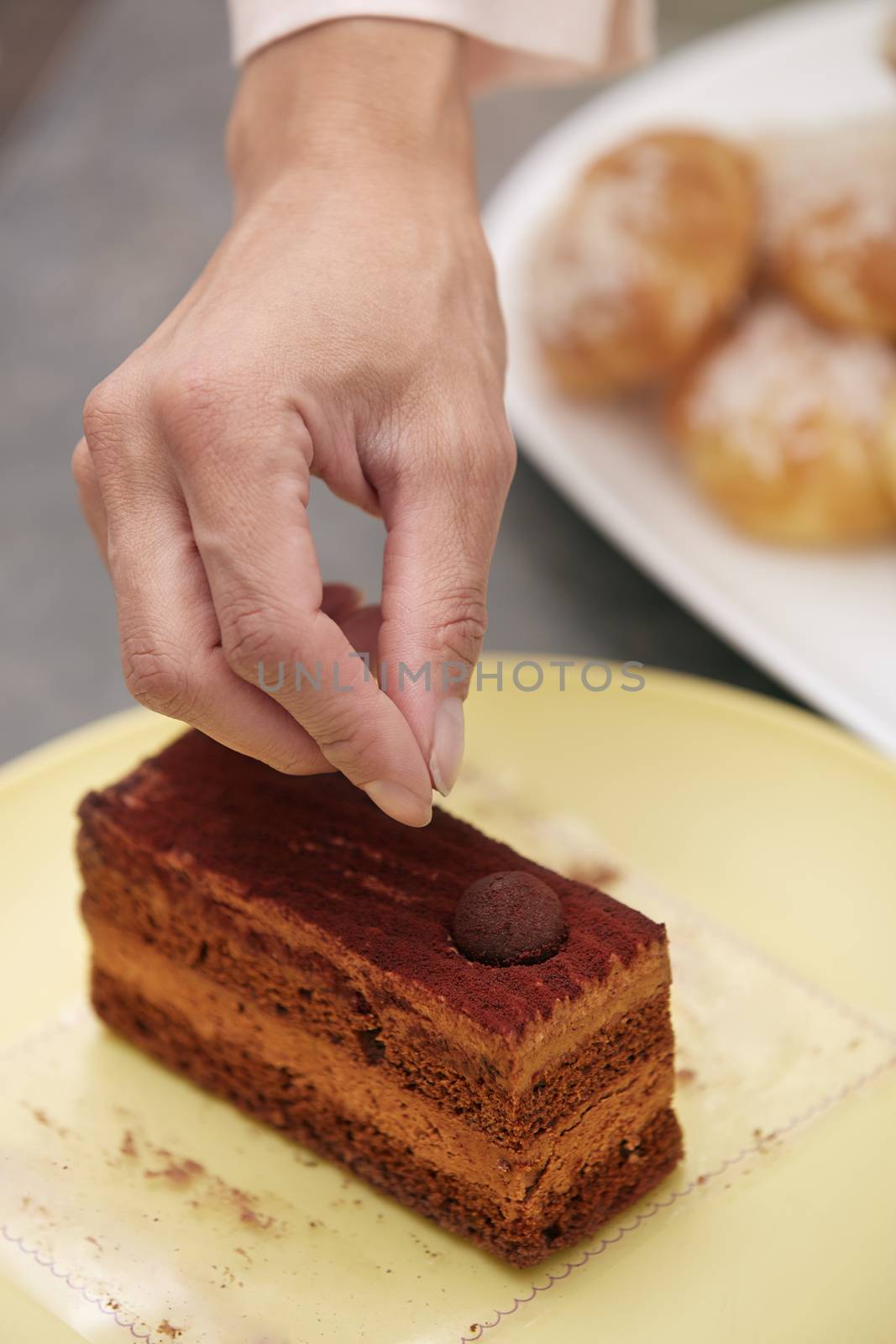 Woman confectioner preparing chocolate cake