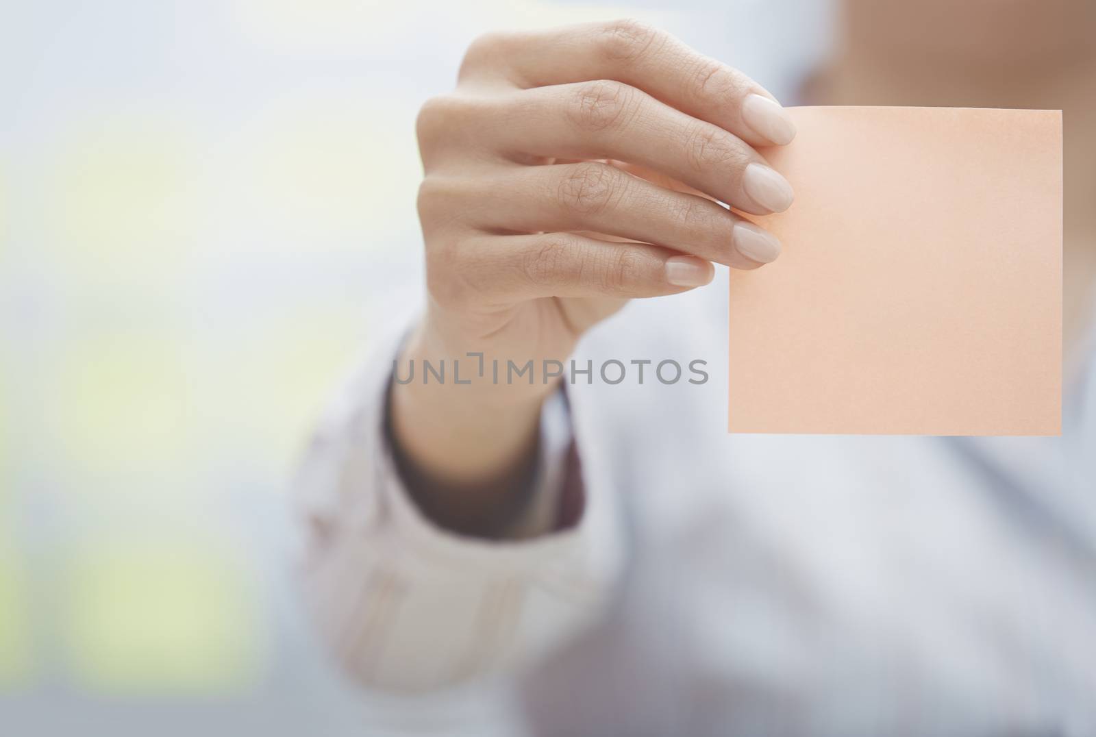 Hand of woman holding sticky note with empty space by Novic